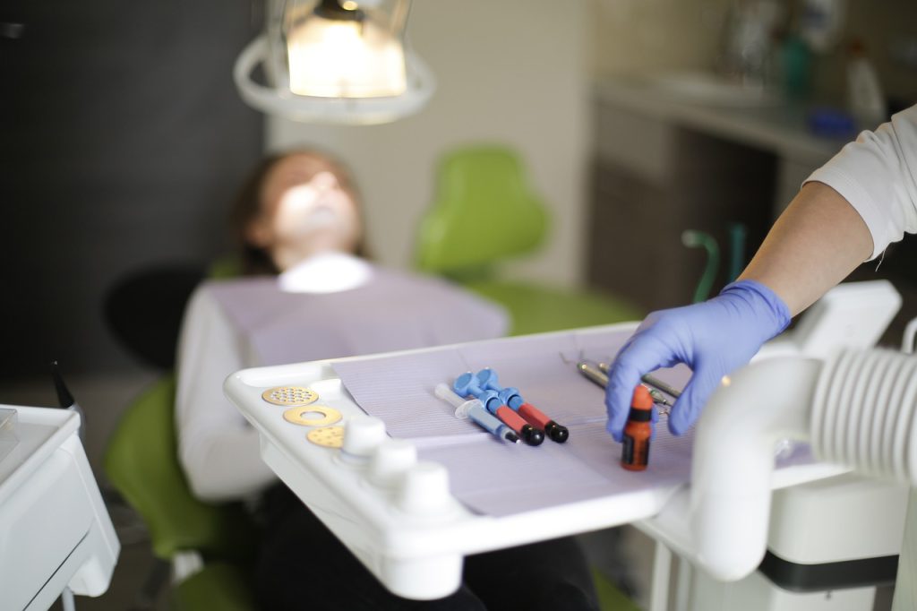 Specjaliści stomatolodzy podczas zabiegu implantacji zęba – nowoczesne leczenie implantologiczne.

