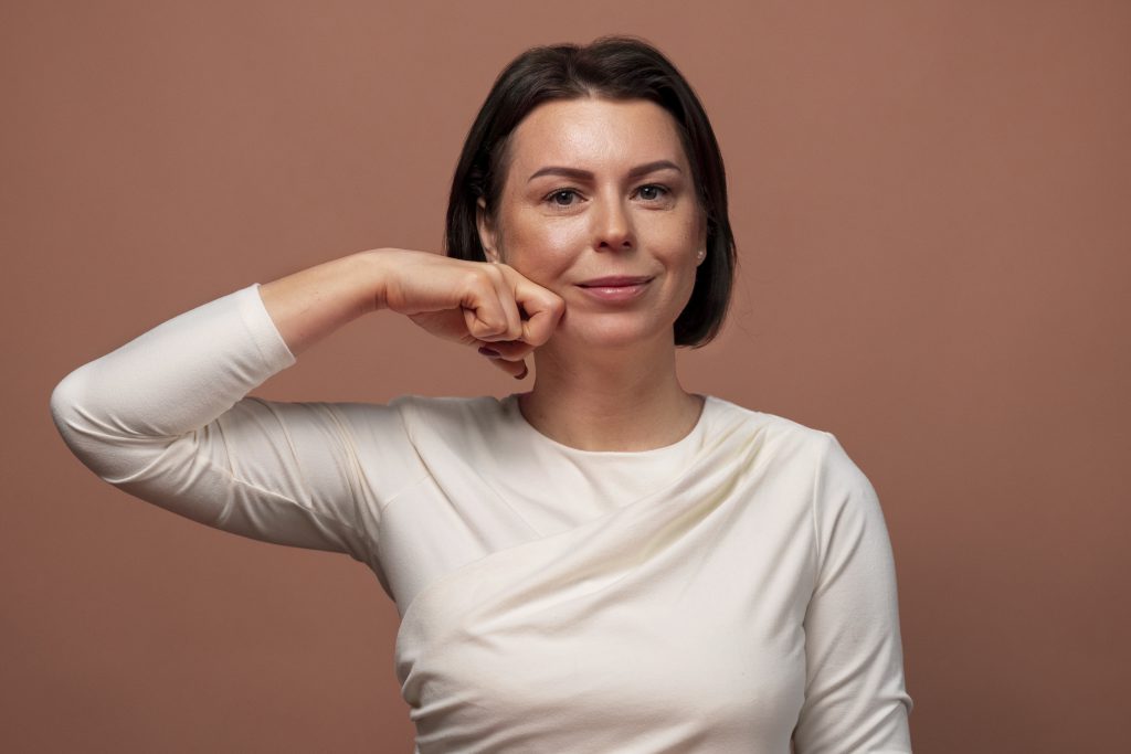 Lipoliza iniekcyjna we Wrocławiu – kobieta podkreślająca piękno i kontury twarzy, efekt naturalnego modelowania, promienna i jędrna skóra po zabiegu