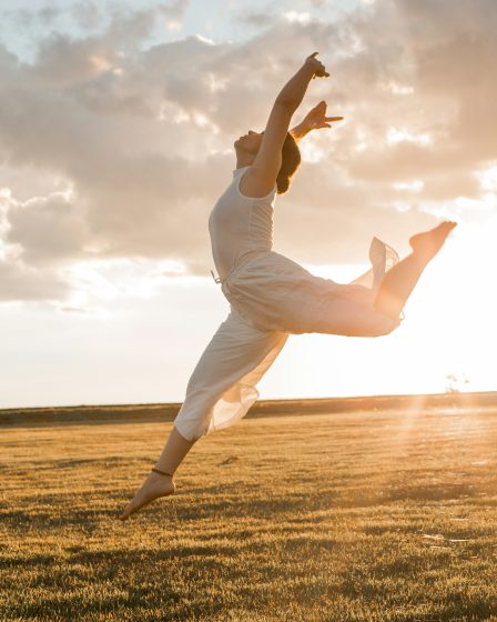zdjęcie tańczącej dziewczyny na tle pola