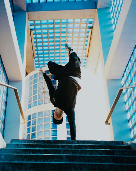 zdjęcie mężczyzny tańczącego na tle wieżowca