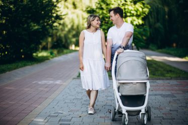 rodzice idą na spacer z dzieckiem w wózku