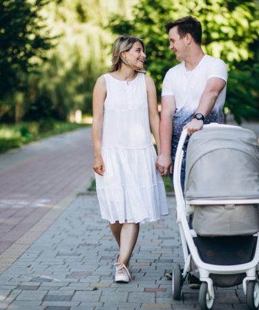 rodzice idą na spacer z dzieckiem w wózku