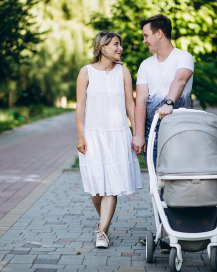 rodzice idą na spacer z dzieckiem w wózku