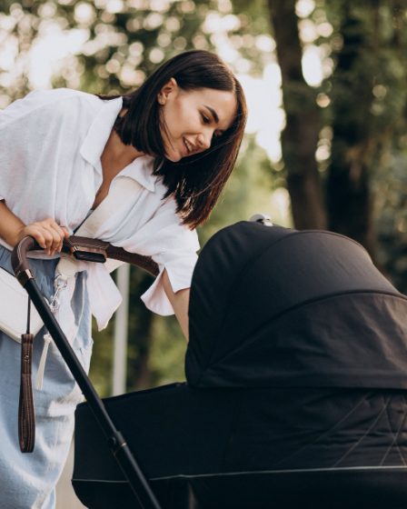 kobieta stojąca obok wózka dla dziecka